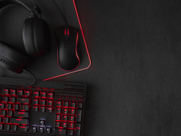 istock gamer workspace concept, top view a gaming gear, mouse, keyboard, joystick, headset, mobile joystick, in ear headphone and mouse pad on black table background. 1051243590