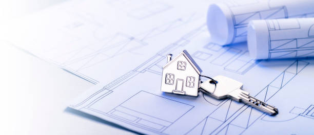 istock Keys with house as keyring on blueprints 1051243706
