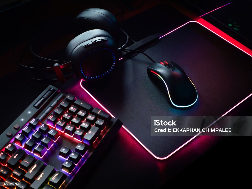 gamer workspace concept, top view a gaming gear, mouse, keyboard with RGB Color, joystick, headset, webcam, VR Headset on black table background. Video Game Stock Photo