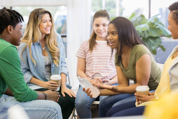 istock Young woman uses humor when sharing with support group 1051247440