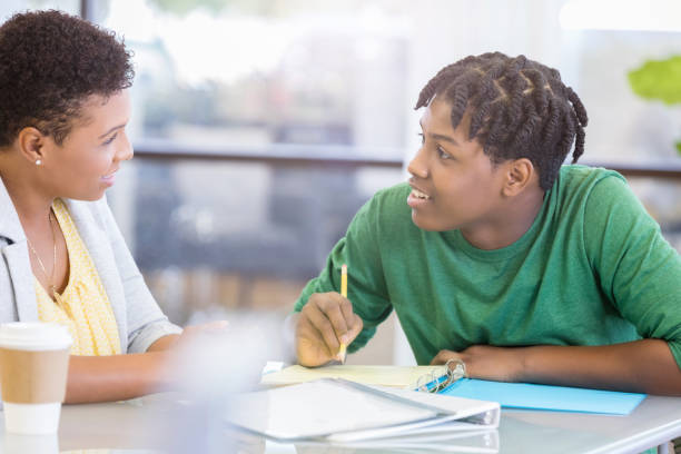 istock Teenage boy discusses homework assignment with mother 1051247478