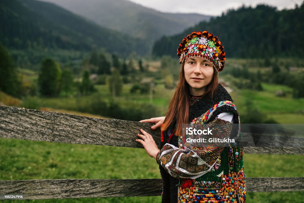 Woman in ethnic and traditional Ukrainian clothes Beautiful caucasian woman wearing ethnic and traditional of the Carpathian mountain Ukrainian clothes. Village background in the autumn. Vyshyvanka Stock Photo