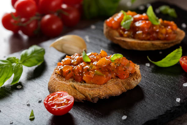 Fresh homemade crispy Italian antipasto called Bruschetta topped with different vegetables stock photo