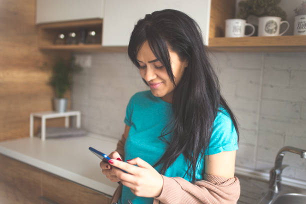 istock Young woman reads her messages while drinking coffee 1051251420