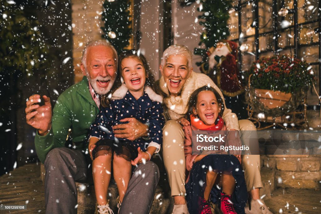 Senior couple with granddaughters Happy two girls outdoors with their grandparents Christmas Stock Photo