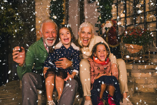Senior couple with granddaughters Happy two girls outdoors with their grandparents multi generation family christmas stock pictures, royalty-free photos & images
