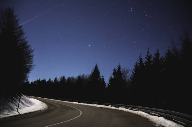 ночное небо над горской дороге. зима - black forest forest sky blue стоковые фото и изображения