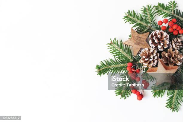 Photo libre de droit de Composition Florale De Style Noël Festif Pommes De Pin Branches Darbres Sapin Baies De Sorbe Rouge Et Bois Étoiles Sur Fond De Tableau Blanc Cadre Décoratif Bannière Web Vue Plate Lapointe Haut Copiez Lespace banque d'images et plus d'images libres de droit de Noël