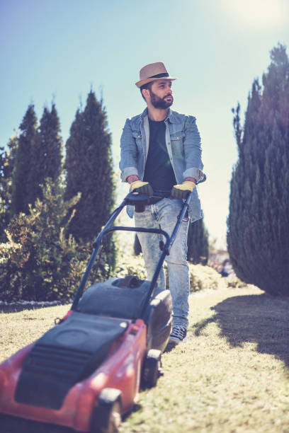 istock Bearded Male Is Mowing A Lawn 1051260436