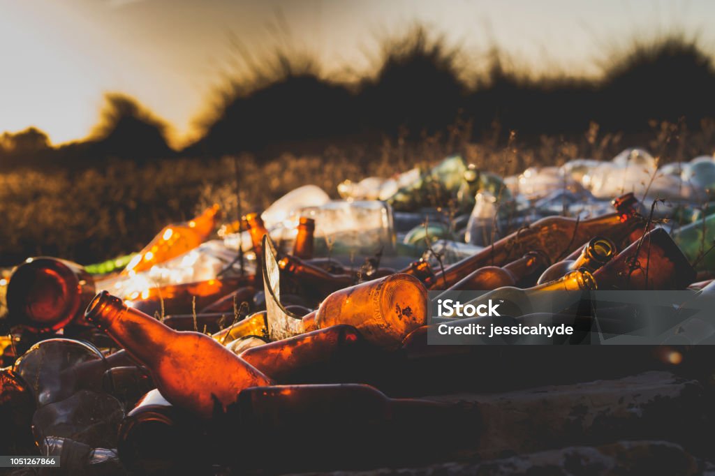 pile of glass bottles waste a pile of glass bottles waste garbage in a filed Bottle Stock Photo