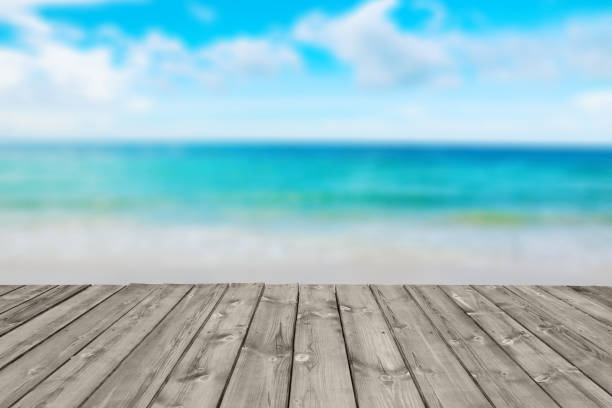 istock blurred tropical beach and ocean with wooden plank 1051273266