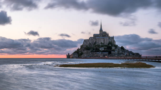 istock Sunset at Le Mont Saint Michelle in summer at high tide 1051273638