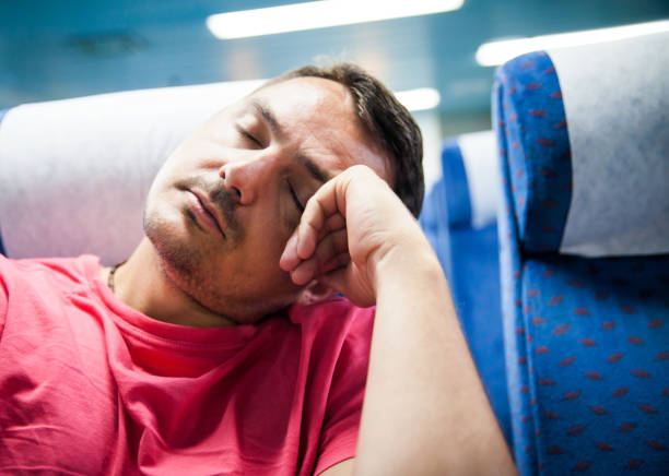 male passenger  taking a nap on the airplane, sitting in a chair