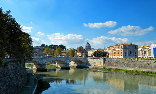 istock Arch Bridge Over River By Buildings Against Blue Sky 1051283178