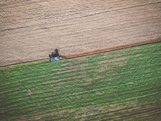 istock Aerial view of tractor plowing the field 1051283384