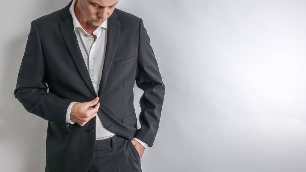 istock Well dressed businessman in white shirt and black suit adjusting his jacket. 1051283496