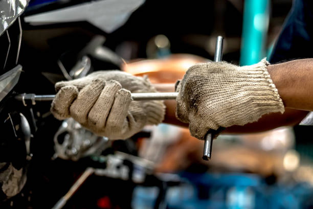 People holding hand are repairing a wrench. Image is close up. People holding hand are repairing a motorcycle Use a wrench and a screwdriver to work. used motorcycle parts stock pictures, royalty-free photos & images