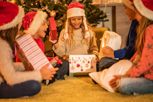 istock Happy kids sitting near Christmas tree 1051292840