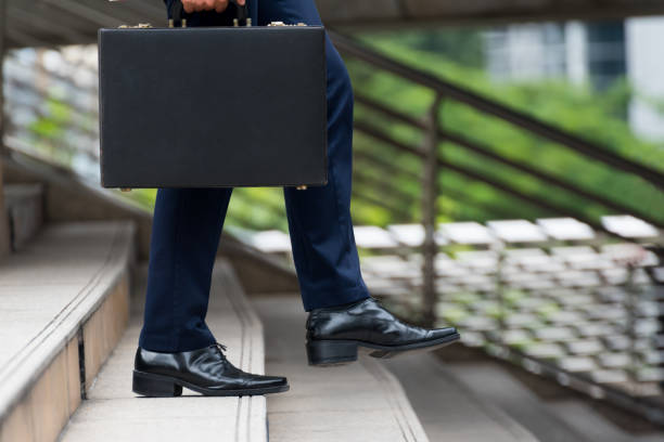 Two businessmen with their luggage. Focus is on the man on the right.