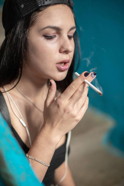 istock A young girl smokes a thin cigarette. 1051294648