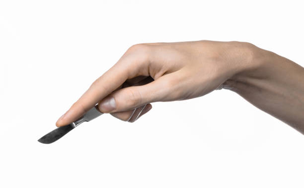 istock The hand holding the scalpel, white background, isolated 1051304536