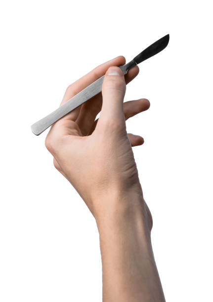 istock The hand holding the scalpel, white background, isolated 1051304580