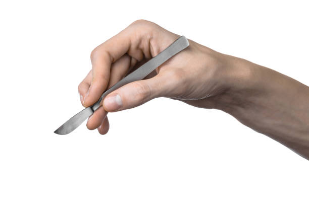 istock The hand holding the scalpel, white background, isolated 1051307698