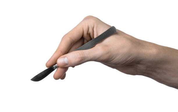 istock The hand holding the scalpel, white background, isolated 1051308852