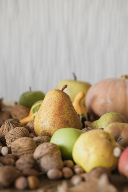 istock Autumn fruits background, apples, pear, nuts, pumpkins 1051314504