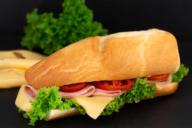 istock Big sandwich with meat and cheese on dark background 1051314624