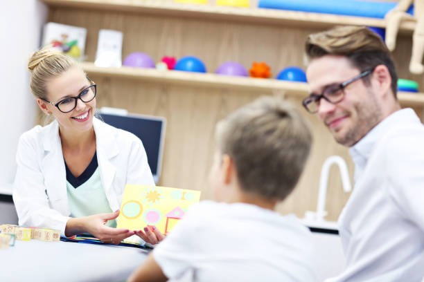 psychologue pour enfants travaillant avec la famille au bureau - male nurse nurse doctor group of people photos et images de collection