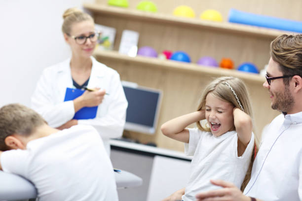 psychologue pour enfants travaillant avec la famille au bureau - male nurse nurse doctor group of people photos et images de collection