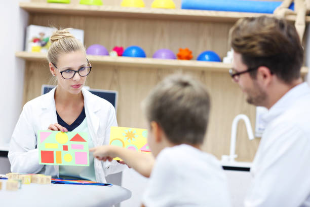 psychologue pour enfants travaillant avec la famille au bureau - male nurse nurse doctor group of people photos et images de collection