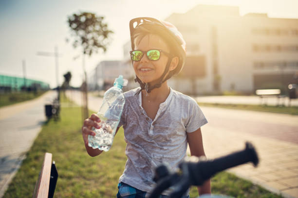 Little boy riding bicycle and drinking water Happy little boy riding bicycle on a hot summer day. The boy is drinking water and pouring it on his face.
Nikon D850 wet bottle stock pictures, royalty-free photos & images