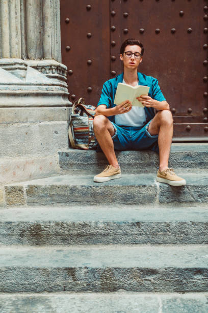 istock Young man reading in old town 1051328330