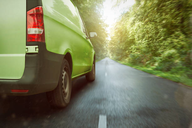 furgão verde carro pela floresta - driving van driver delivering - fotografias e filmes do acervo