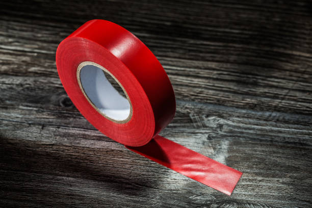 istock Red rolled duct tape on vintage wooden board 1051332204