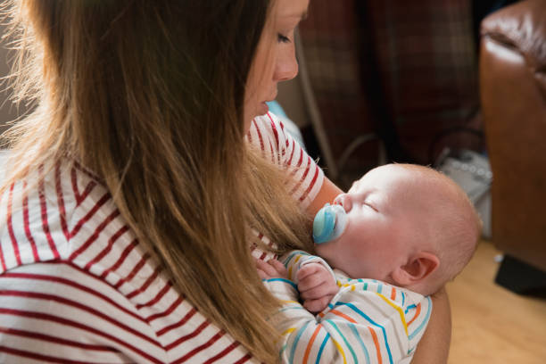 istock Sleeping Newborn in Mothers Arms 1051332498