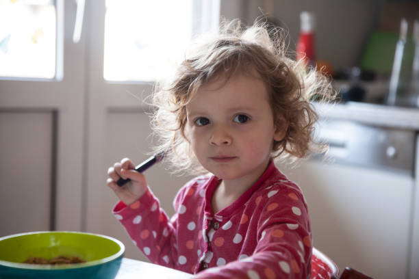 istock Cute Girl Sitting At Table 1051333778