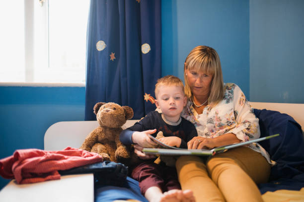 story time przed snem - grandmother reading child grandson zdjęcia i obrazy z banku zdjęć