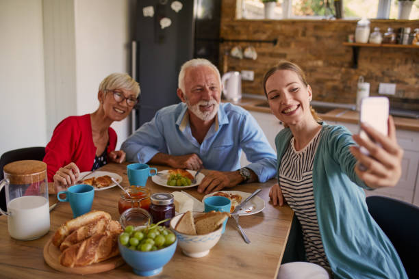 istock Daughter taking pictures with parents during breakfast 1051339710