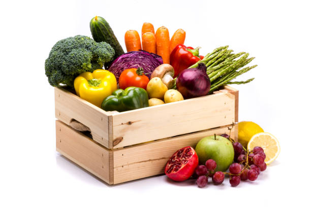 Pine box full of colorful fresh vegetables and fruits on a white background stock photo
