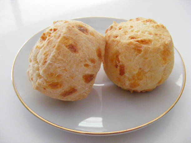 istock Homemade cheese biscuits on a white plate with a golden trimming. 1051366412