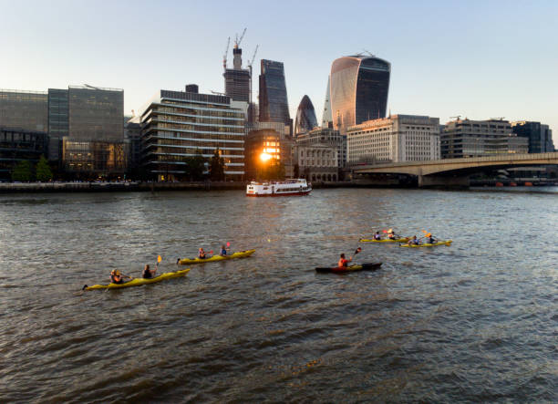 London, UK - November 16, 2014: A group of kayaks going past the skyscrapers of the City of London, UK. Shot with an iPhone.