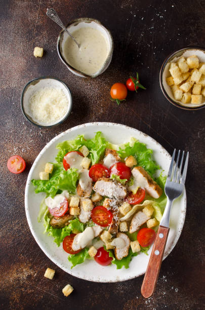 istock Caesar salad with chicken, tomatoes, Parmesan and croutons 1051369512