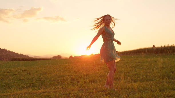 istock LENS FLARE: Happy young dancer spinning outdoors on a pleasant rainy evening. 1051371860