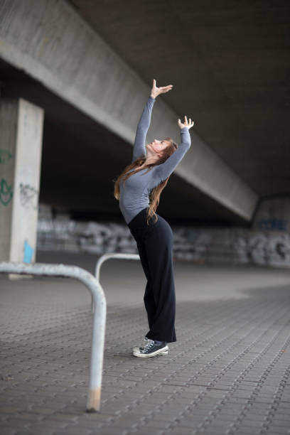 istock Side View Of Young Woman Dancing Under Bridge 1051372318
