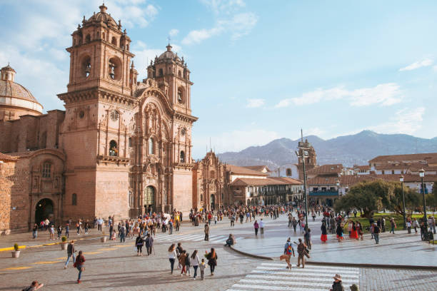 Candid Scene In Front Of The Iglesia De La Compañia De Jesús (Church of the Society of Jesus) In Cuzco, Peru Candid scene of pedestrians in the Plaza de Armas with the Church of the Society of Jesus in the background in Cusco, Peru peru travel stock pictures, royalty-free photos & images
