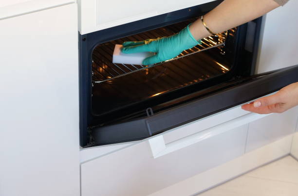 istock Woman hand in protective green gloves cleaning white kitchen 1051380942