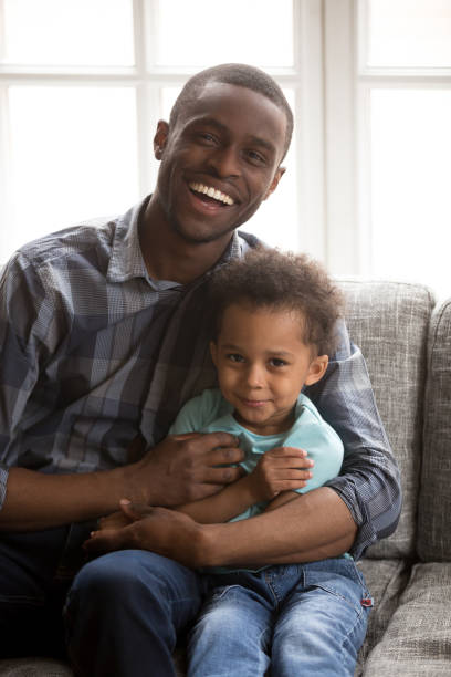 istock Loving father with little son sitting looking at camera indoors 1051381268